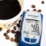 Un bicchiere d'acqua accanto a una tazza di caffè su un tavolo, simbolizzando l'importanza dell'idratazione.