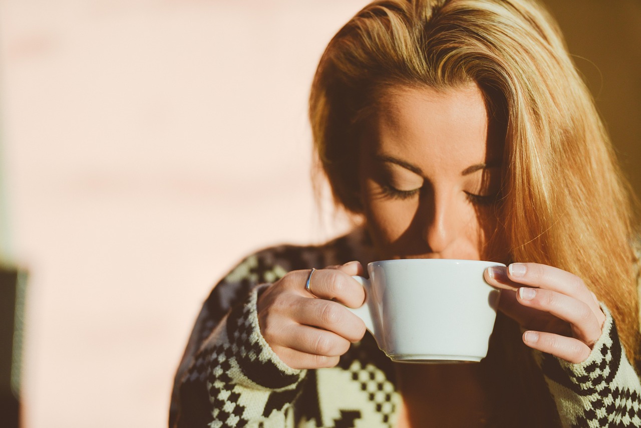 Tazza di caffè su un tavolo, con fondo sfocato di un ambiente mattutino.