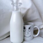 Un vaso de leche caliente sobre una mesa, con un fondo suave y relajante, ideal para la noche.